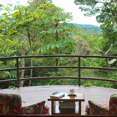 Blick auf eine Sitzecke mit Ausblick auf den Nebelwald nahe der Pension Cala Lodge