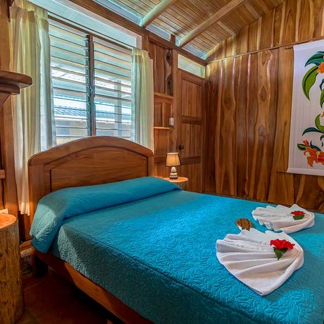 Blick auf ein Bett im Standardzimmer in der Dschungel-Lodge La Cusinga Lodge
