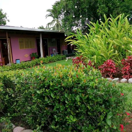Cabinas Marcelina Garten Blick auf das rosa Haus direkt im blühenden Garten