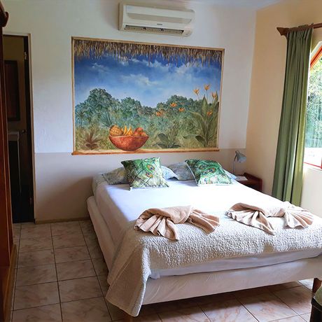 Blick auf ein Bett im Deluxebungalow Diquis del Sur