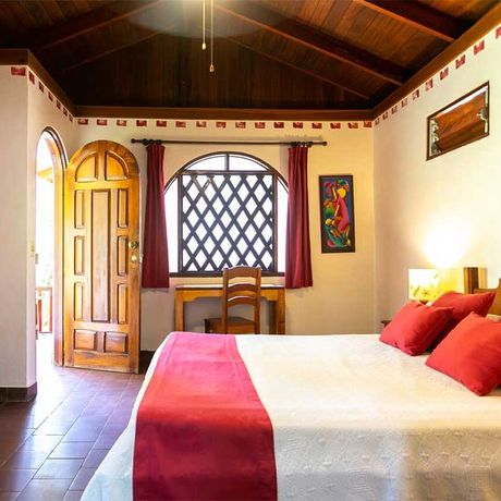 Blick auf ein Bett des Bungalows der Strandunterkunft B&B El Encanto Inn