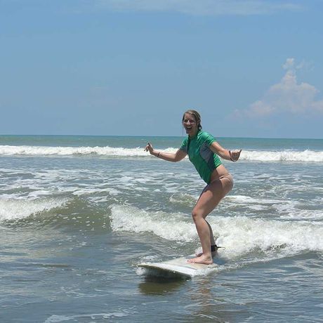 Blick auf eine Surferin beim Surfkurs in Dominical