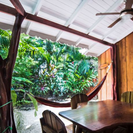 Bungalows-und-Cabinas-Pequeño-Gecko-Verde-Superiorzimmer 03 Die Außenterasse des Superiorzimmers wurde mit praktischen Holzmöbeln sowie einer Hängematte ausgestattet.