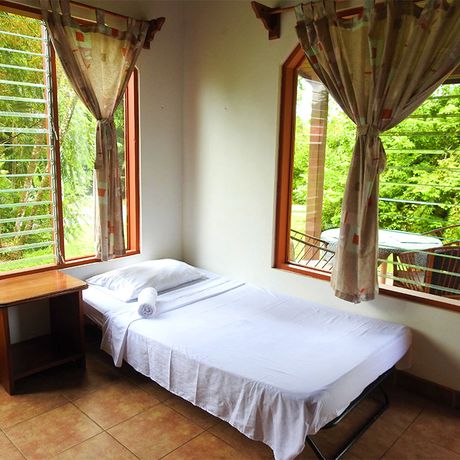 Blick auf ein Bett im Großen Bungalow Diquis del Sur