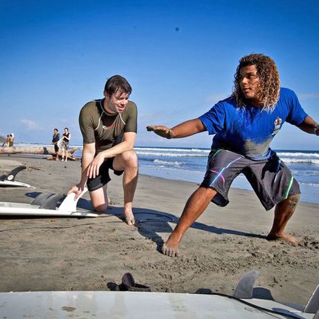 Trockenübungen Surfen Montezuma Blick auf Mann bei Trockenübungen mit Surflehrer am Strand