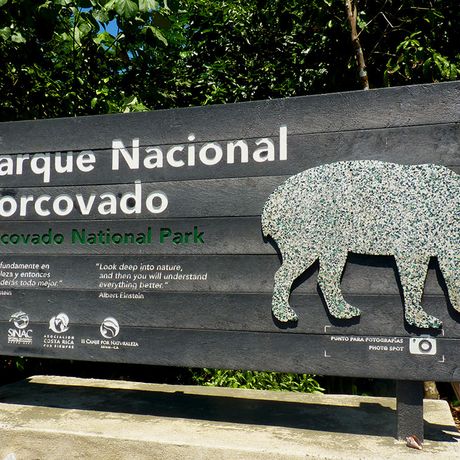 Blick auf das Eingangsschild des Nationalparks Corcovado mit Abbildung eines Tapirs 