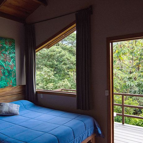 Blick auf ein Doppelbett in einem Standardzimmers der Pension Cala Lodge