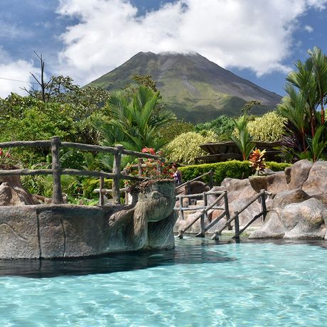 Costa Rica Resort Pool Thermalpool eines Resorts mit Blick auf einen wolkenumhangenen Vulkan