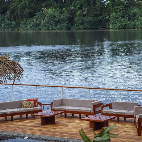 Tortuga Lodge Sitzbereich Fluss Blick auf einen Sitzbereich auf einer Terrasse am Fluss der Tortuga Lodge