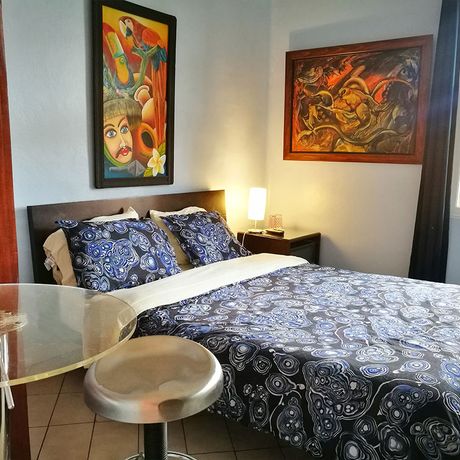 Casa 69 Economyzimmer 03 Das Economyzimmer ist mit einem Doppelbett möbliert und mit tropischen Bildern dekoriert.
